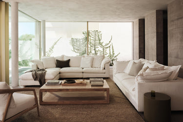 living room setting with white couches, old elm timber rectangle coffee table and travertine top, natural rug