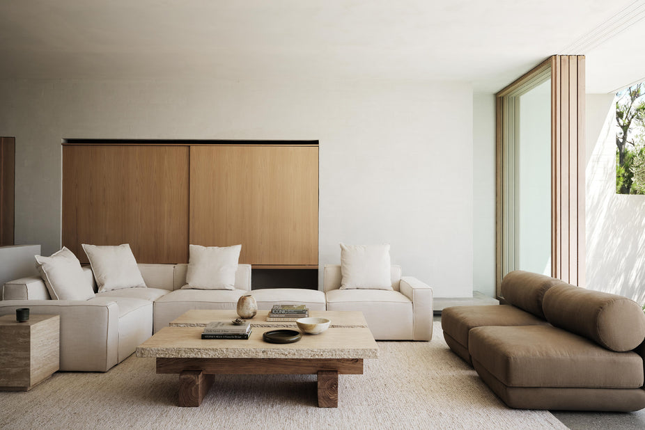 living room setting with cream sofa and olive green armchairs and travertine and timber coffee table