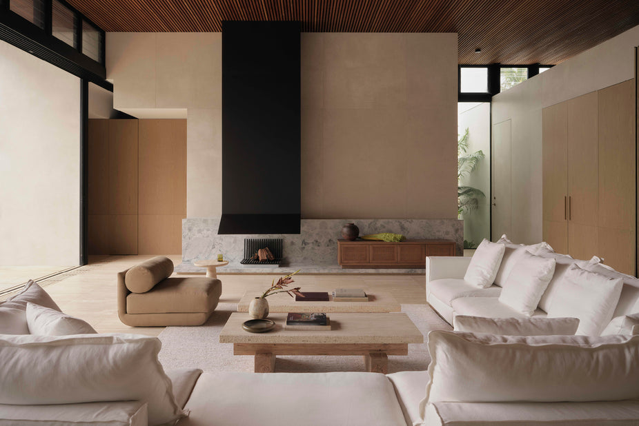 living room setting, white sofa, brown armchair , travertine coffee table